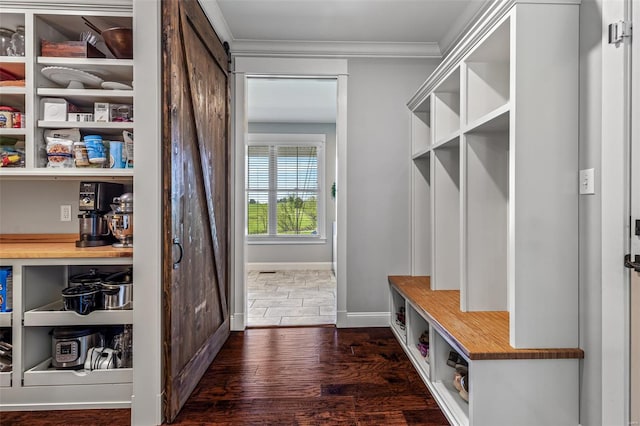 mudroom with a barn door, baseboards, dark wood finished floors, and crown molding