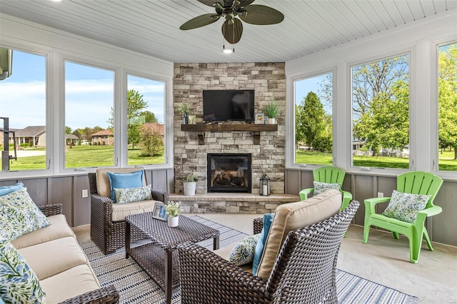 sunroom / solarium with a wealth of natural light, an outdoor living space with a fireplace, and ceiling fan