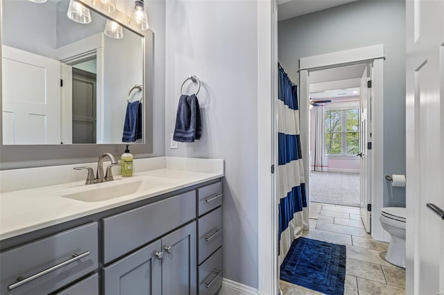 full bathroom with vanity, toilet, and baseboards