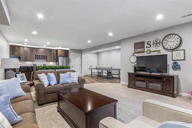 living area with baseboards, light carpet, visible vents, and recessed lighting