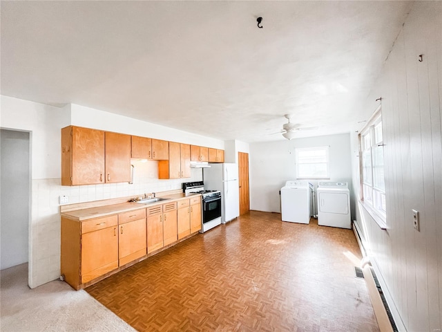kitchen featuring under cabinet range hood, a sink, white appliances, separate washer and dryer, and ceiling fan