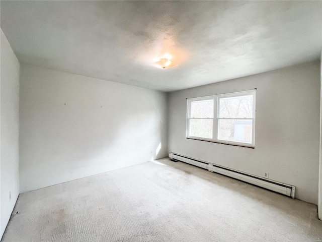 carpeted spare room featuring baseboard heating
