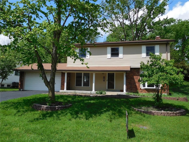 traditional home featuring a porch, driveway, brick siding, a front lawn, and an attached garage