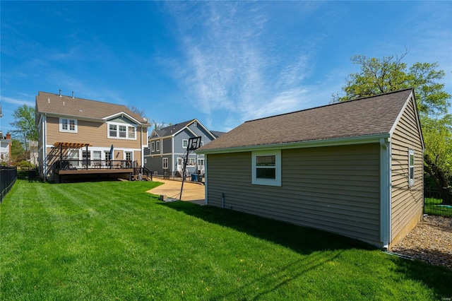 rear view of house with a yard, fence, and a wooden deck