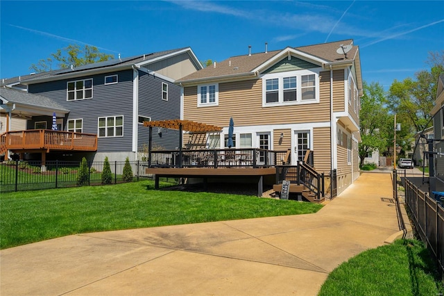 back of house with a lawn, a wooden deck, a pergola, and fence