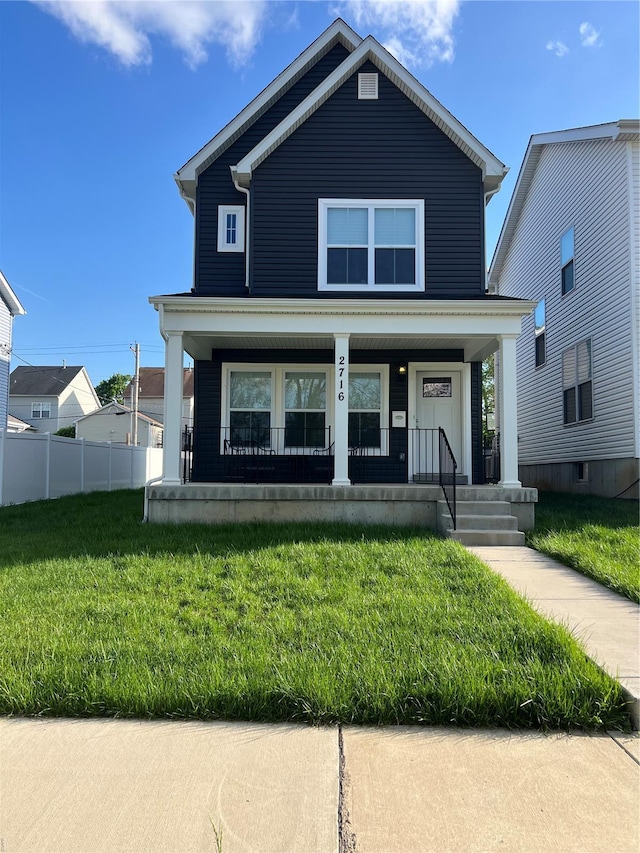 view of front of property with fence, a porch, and a front yard