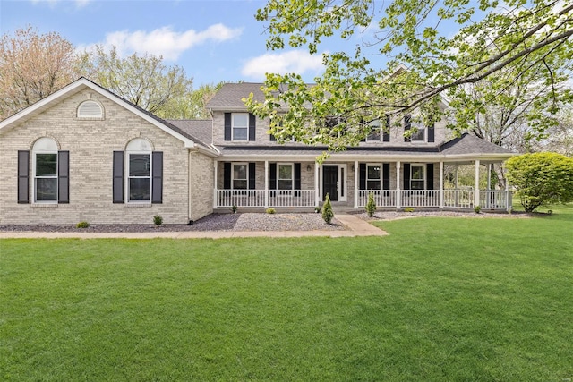 back of house featuring brick siding, a porch, a yard, and a shingled roof