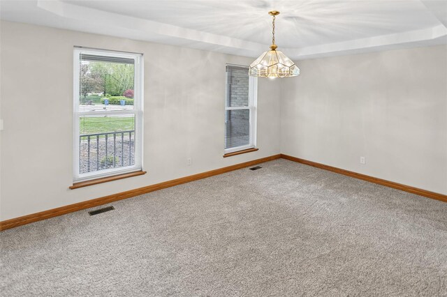 empty room with carpet, visible vents, baseboards, and a notable chandelier