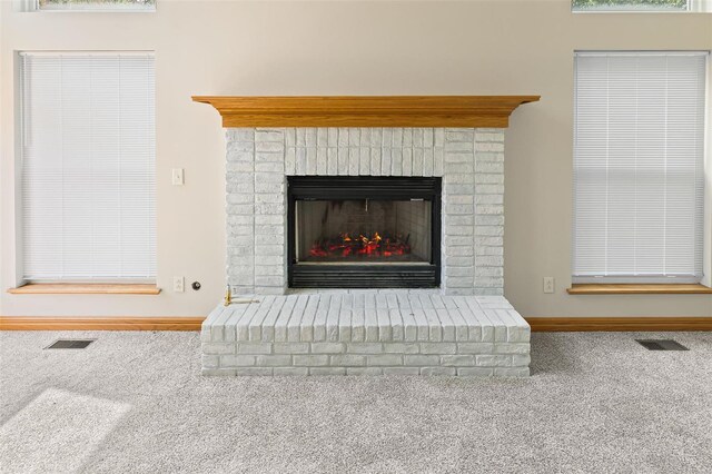 room details with visible vents, baseboards, carpet flooring, and a fireplace