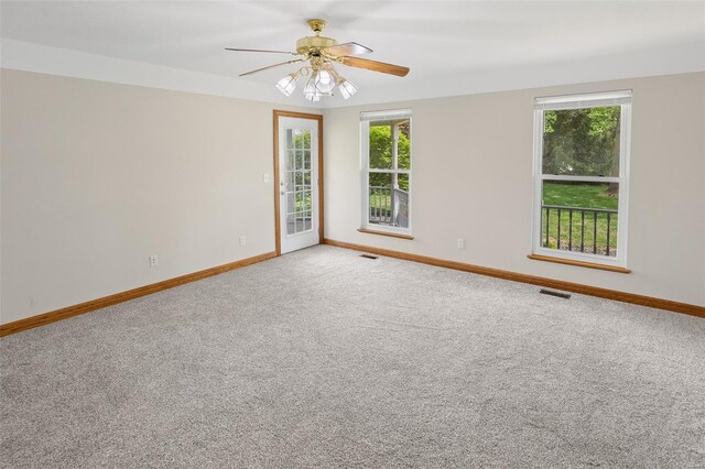 carpeted empty room with visible vents, baseboards, and ceiling fan