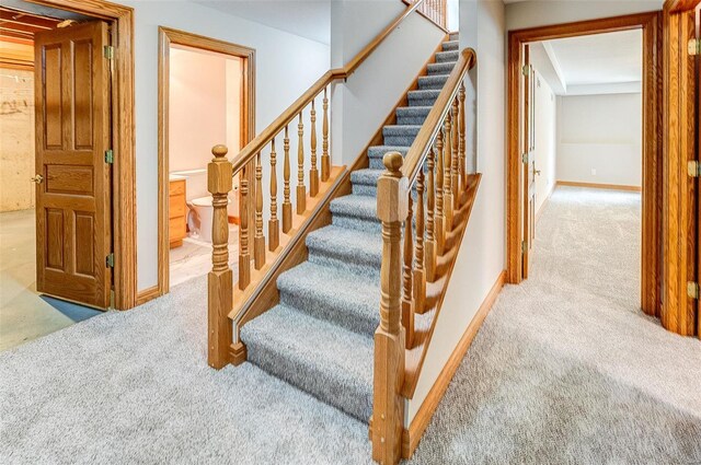 staircase with baseboards and carpet