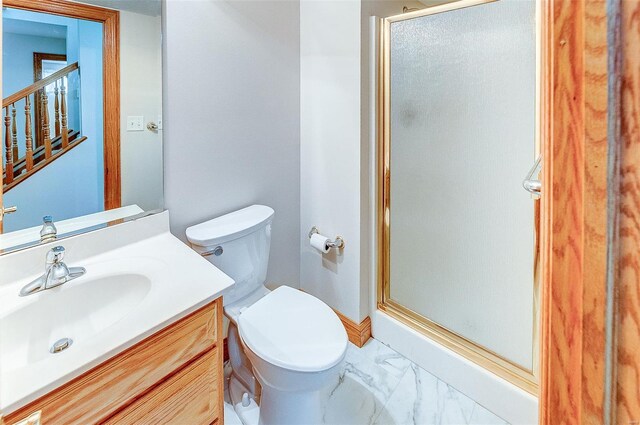 bathroom featuring vanity, marble finish floor, a stall shower, and toilet