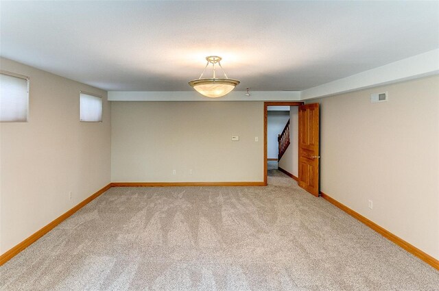 unfurnished room featuring light colored carpet, baseboards, and visible vents