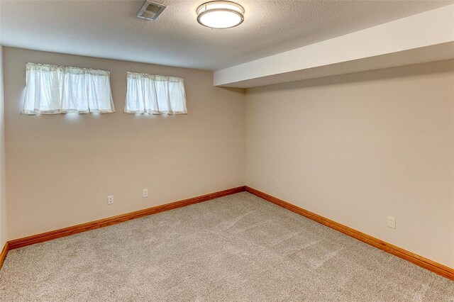 spare room with baseboards, visible vents, and light colored carpet