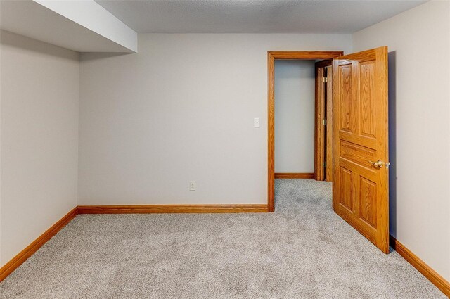 unfurnished room featuring carpet floors and baseboards