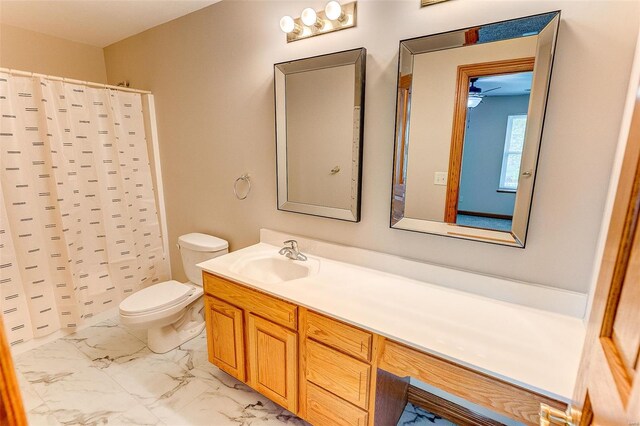 full bathroom with marble finish floor, curtained shower, vanity, and toilet