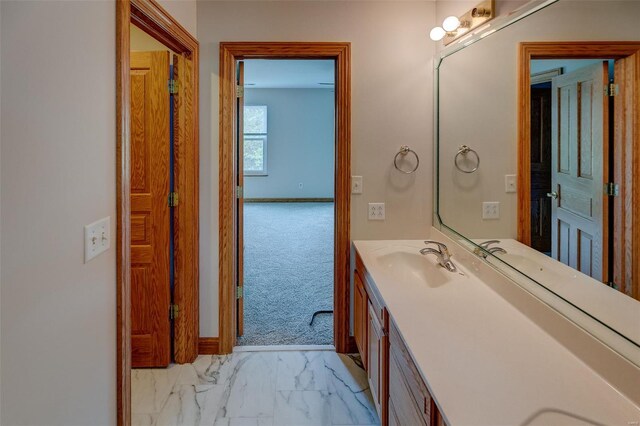 bathroom featuring baseboards, marble finish floor, and vanity