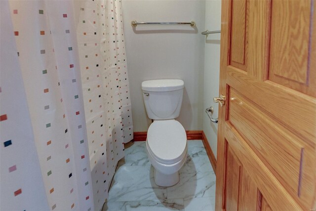 full bathroom featuring marble finish floor, a shower with shower curtain, and toilet