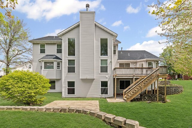 rear view of property featuring stairway, a chimney, a yard, and a deck