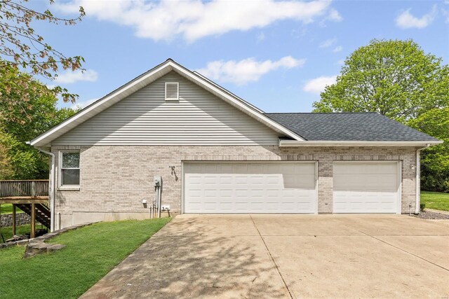 view of side of property featuring roof with shingles, driveway, a lawn, brick siding, and a garage