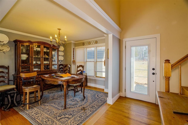 dining room featuring baseboards, a notable chandelier, crown molding, and light wood-style flooring