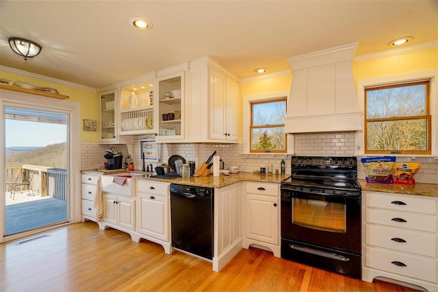 kitchen with custom exhaust hood, decorative backsplash, black appliances, light wood finished floors, and crown molding