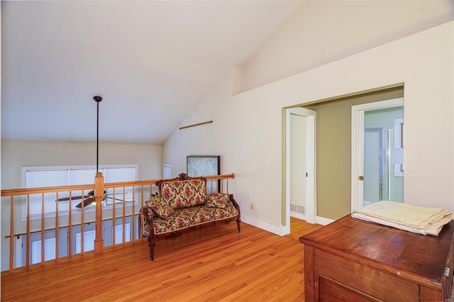 sitting room with visible vents, ceiling fan, baseboards, light wood-type flooring, and high vaulted ceiling