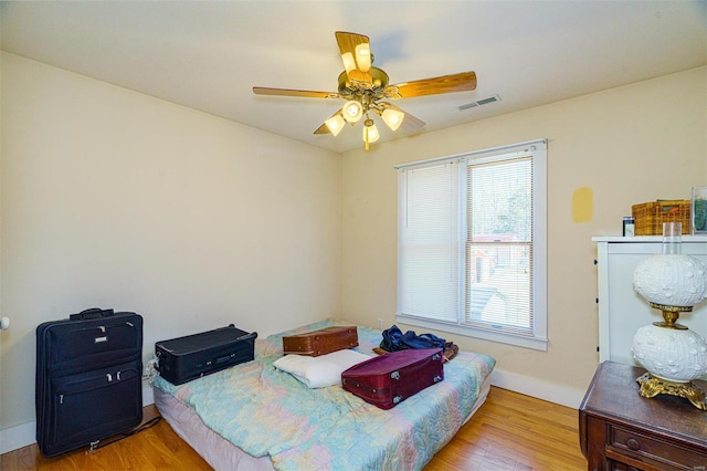 bedroom with a ceiling fan, visible vents, baseboards, and light wood-style floors