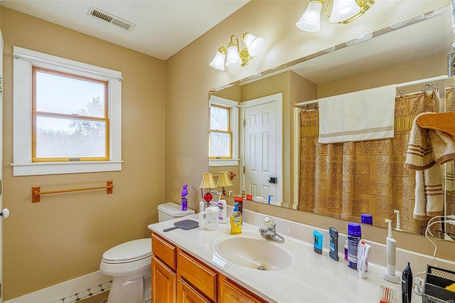 bathroom featuring tile patterned flooring, toilet, vanity, baseboards, and visible vents