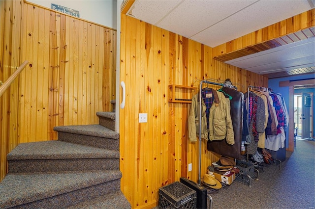 stairs with wood walls and carpet