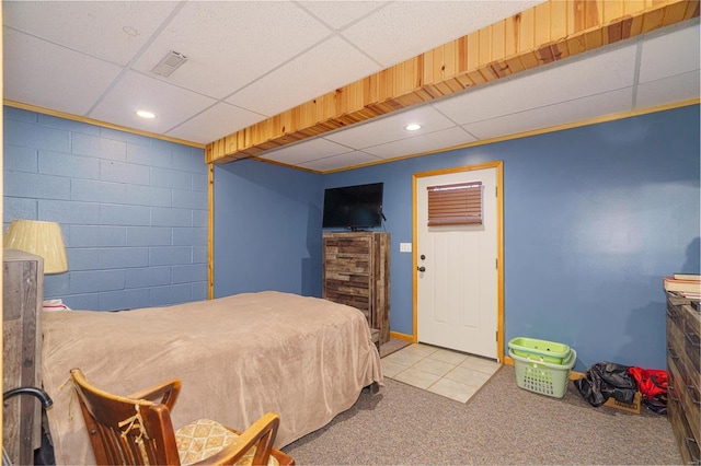 bedroom with recessed lighting, concrete block wall, carpet flooring, and a paneled ceiling