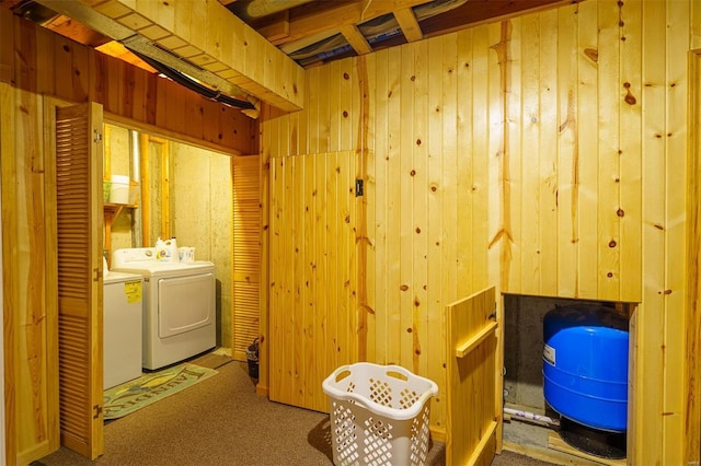 laundry area featuring washing machine and clothes dryer, wooden walls, laundry area, and carpet floors