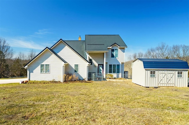 view of front of house with a front yard, an outdoor structure, a shed, a chimney, and fence