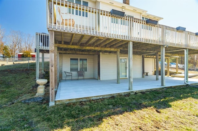 back of house with fence, a wooden deck, and a yard