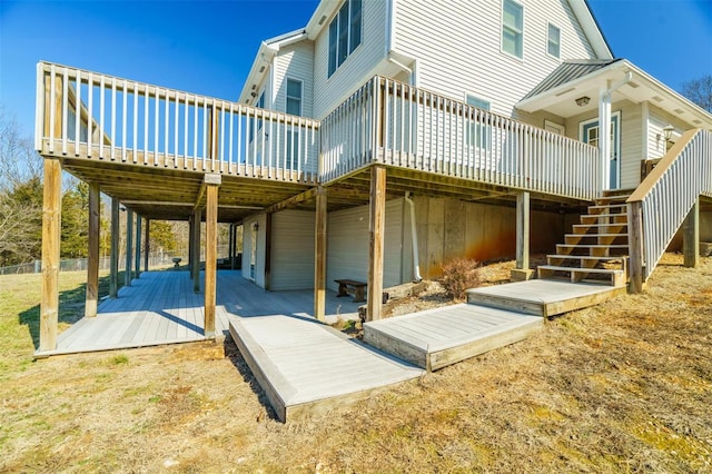 rear view of property with a deck, stairs, and a standing seam roof