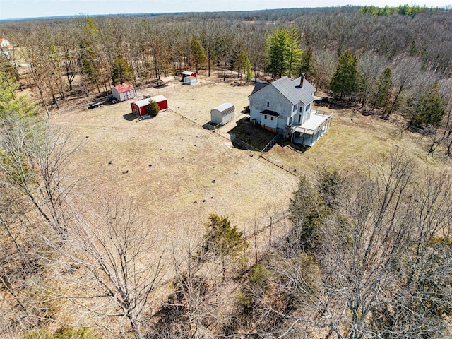 drone / aerial view featuring a wooded view and a rural view