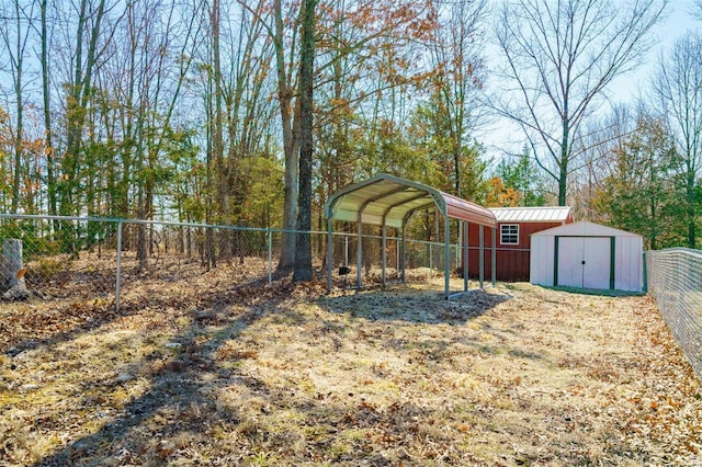 view of yard featuring a storage unit, a carport, an outdoor structure, and a fenced backyard
