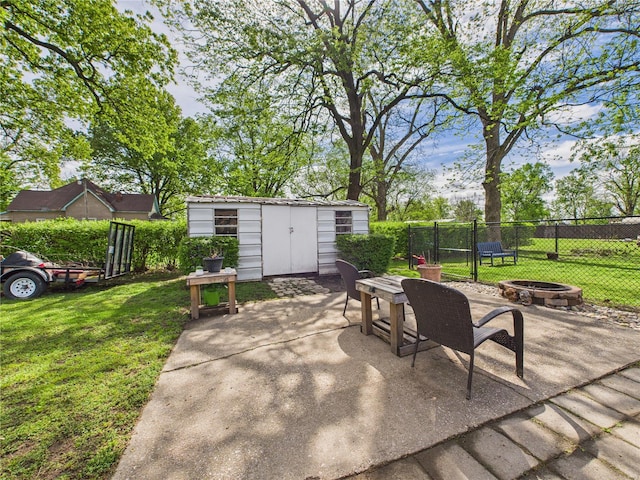 view of patio featuring fence, an outdoor fire pit, an outbuilding, and a storage shed