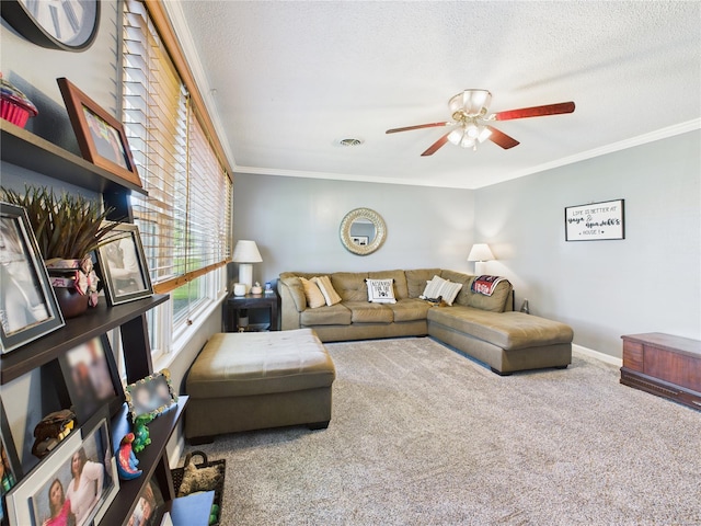living area with a ceiling fan, a textured ceiling, carpet, baseboards, and ornamental molding