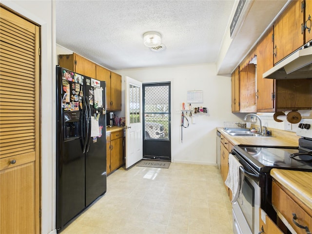 kitchen with brown cabinets, light countertops, stainless steel appliances, and a sink