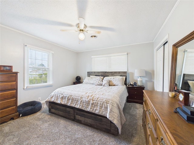 bedroom featuring a textured ceiling, visible vents, ceiling fan, crown molding, and carpet floors