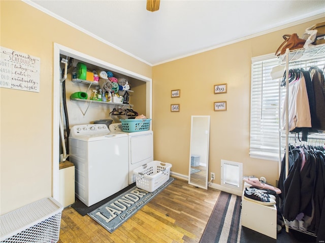 washroom featuring laundry area, ornamental molding, wood-type flooring, washing machine and clothes dryer, and baseboards