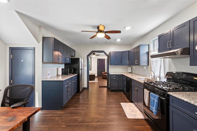 kitchen with a sink, dark wood-type flooring, under cabinet range hood, a ceiling fan, and black appliances