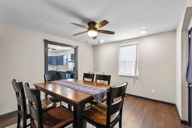dining room with dark wood-style flooring, a ceiling fan, and baseboards