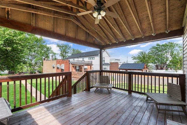 deck featuring a yard, a residential view, and a ceiling fan