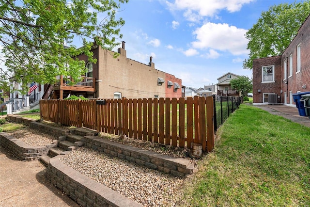 view of yard featuring a residential view, fence, and central AC