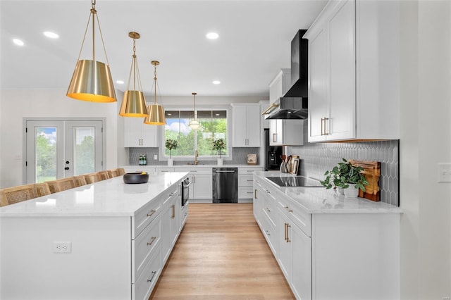 kitchen with dishwashing machine, wall chimney range hood, black electric cooktop, white cabinets, and backsplash