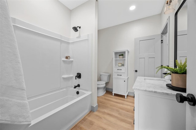 bathroom featuring shower / bath combination, wood finished floors, vanity, baseboards, and toilet