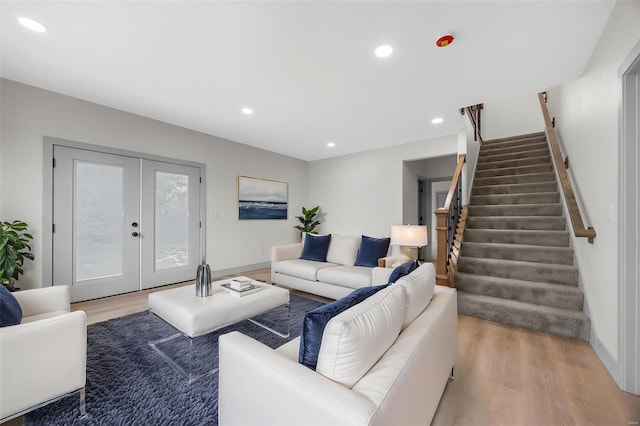 living room with light wood-type flooring, recessed lighting, stairs, and french doors