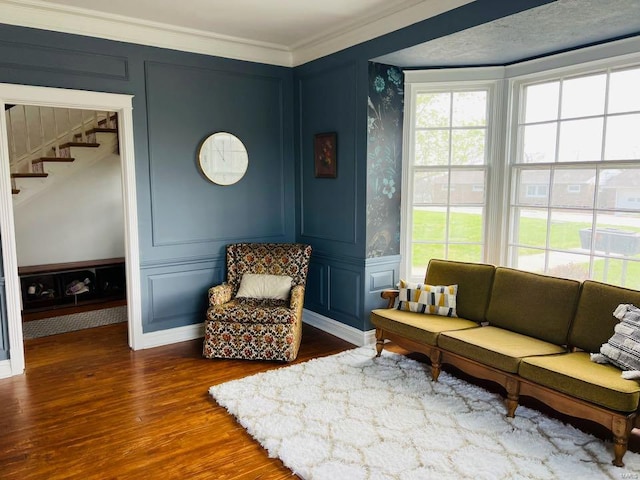 living area featuring a decorative wall, stairs, and plenty of natural light
